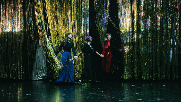 Performers on stage hand by hand